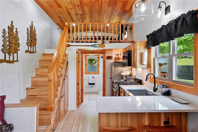 319 Ferry Ln, North-Other Area, PA 16370 - kitchen with a sink, stainless steel range with gas cooktop, wood walls, light wood-style flooring, and light countertops