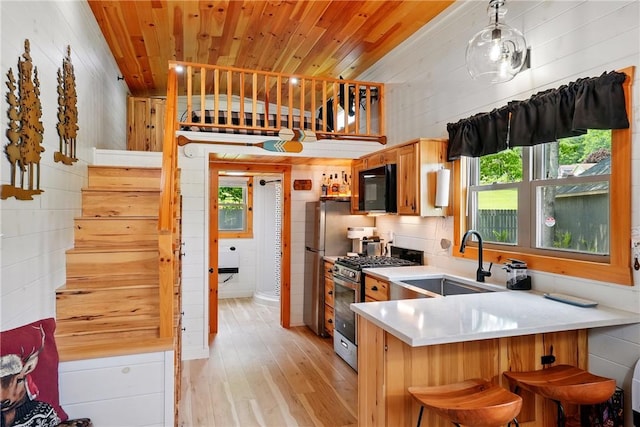 319 Ferry Ln, North-Other Area, PA 16370 - kitchen featuring a sink, appliances with stainless steel finishes, light wood-type flooring, light countertops, and a breakfast bar area