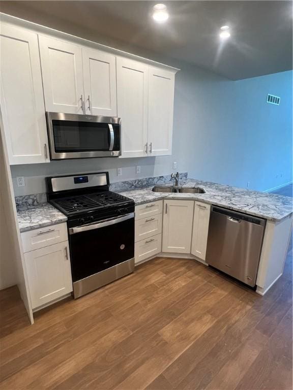 1558 NW Parkwood Pointe Dr, Moon/Crescent Twp, PA 15046 - kitchen with appliances with stainless steel finishes, a sink, light wood-style flooring, white cabinetry, and a peninsula