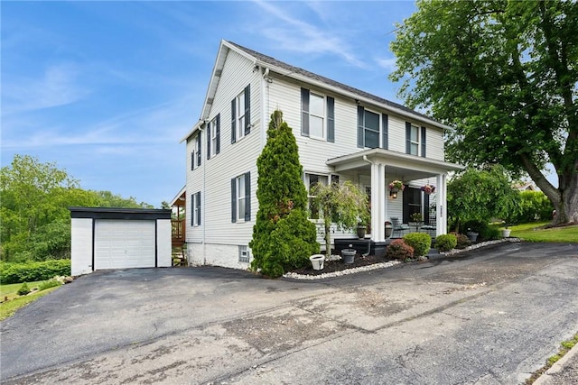 203 E Main St, New Alexandria, PA 15670 - view of front facade featuring an outbuilding, a porch, asphalt driveway, and a detached garage