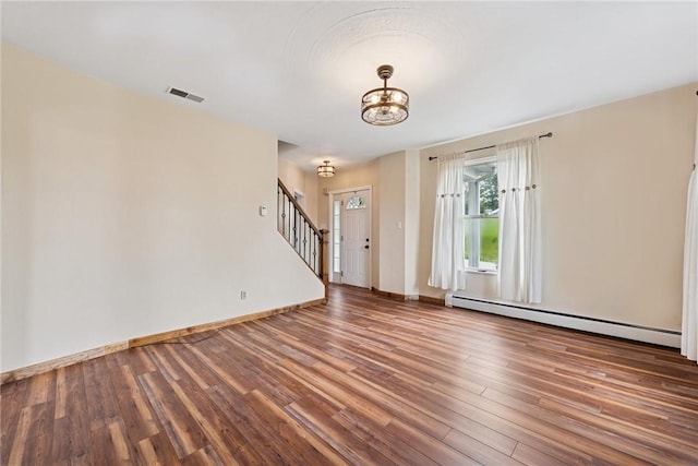 203 E Main St, New Alexandria, PA 15670 - spare room featuring a baseboard radiator, wood finished floors, a chandelier, stairs, and baseboards
