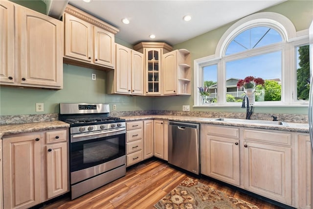 203 E Main St, New Alexandria, PA 15670 - kitchen with stainless steel appliances, a sink, light brown cabinetry, wood finished floors, and glass insert cabinets