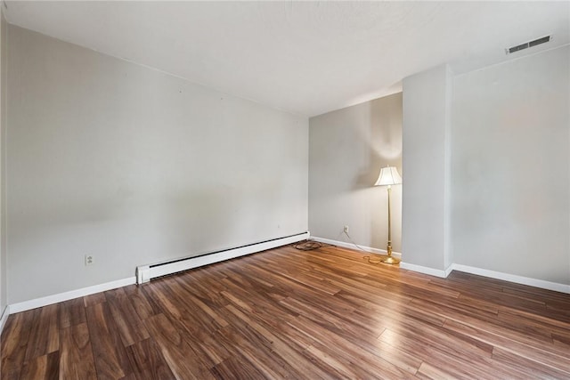 203 E Main St, New Alexandria, PA 15670 - empty room with a baseboard heating unit, wood finished floors, and baseboards