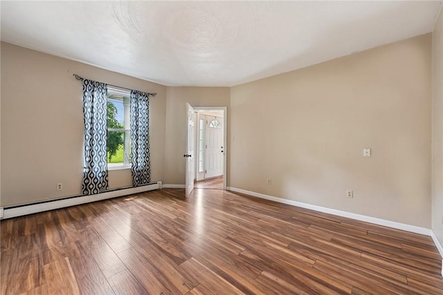 203 E Main St, New Alexandria, PA 15670 - spare room featuring a baseboard radiator, wood finished floors, and baseboards