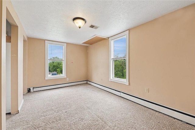 203 E Main St, New Alexandria, PA 15670 - carpeted spare room featuring a textured ceiling, baseboard heating, and healthy amount of natural light