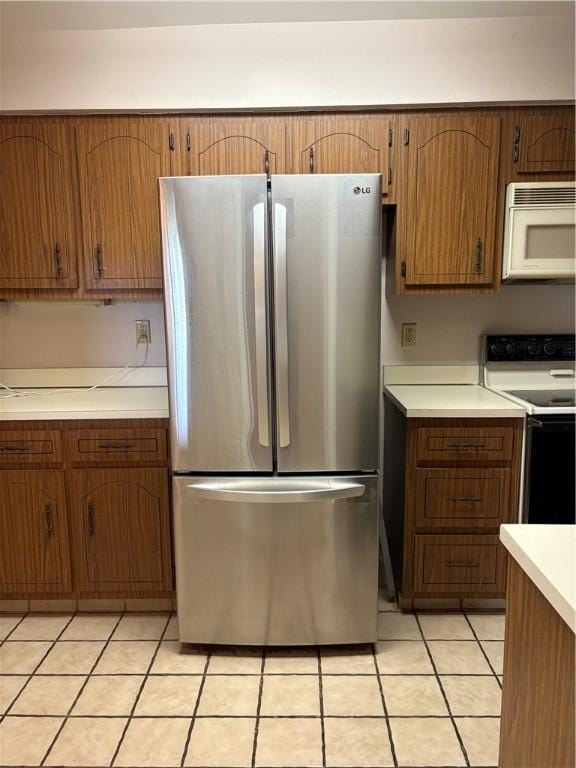 220 N Dithridge Unit 907, Oakland, PA 15213 - kitchen with freestanding refrigerator, white microwave, electric range, light countertops, and brown cabinetry