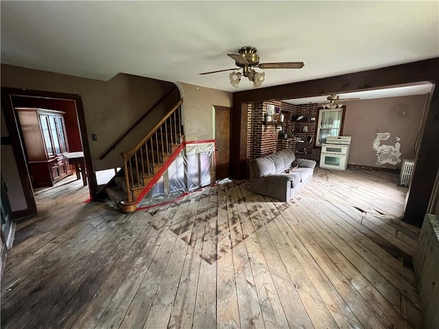 140 Smartnick Rd, Hempfield Twp Wml, PA 15601 - unfurnished living room with wood-type flooring, ceiling fan, stairs, radiator, and baseboards