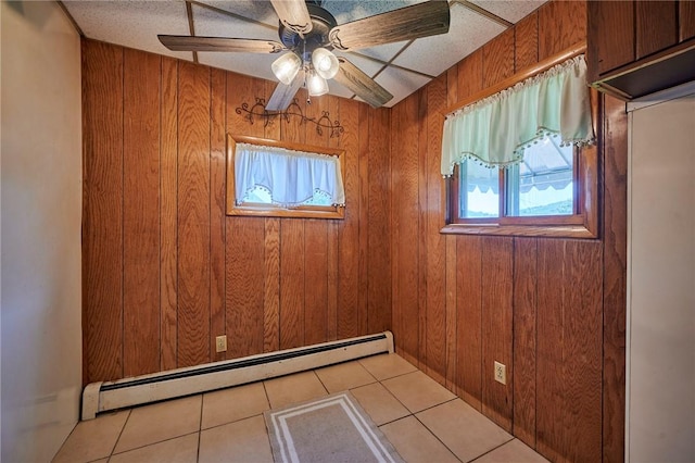 320 Garfield St, W Kittanning Boro, PA 16201 - unfurnished room with a baseboard heating unit, wood walls, light tile patterned floors, and a ceiling fan