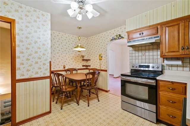 420 N St, Springdale Boro, PA 15144 - kitchen featuring under cabinet range hood, stainless steel range with electric cooktop, light countertops, light floors, and brown cabinets