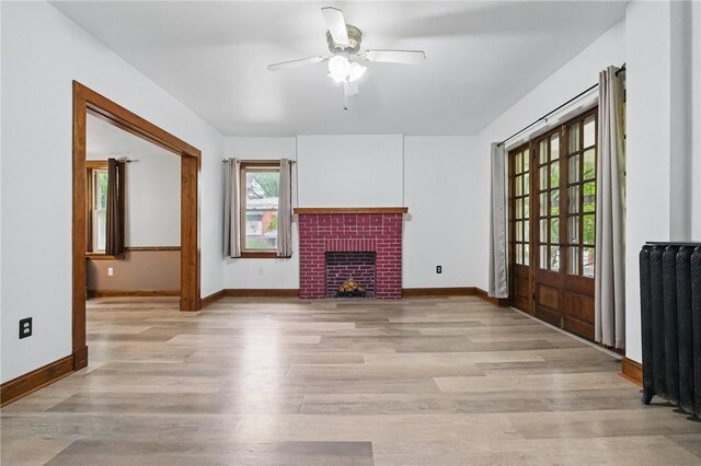 3855 Hiawatha St, Brighton Heights, PA 15212 - unfurnished living room featuring radiator, ceiling fan, light wood-style flooring, baseboards, and a fireplace