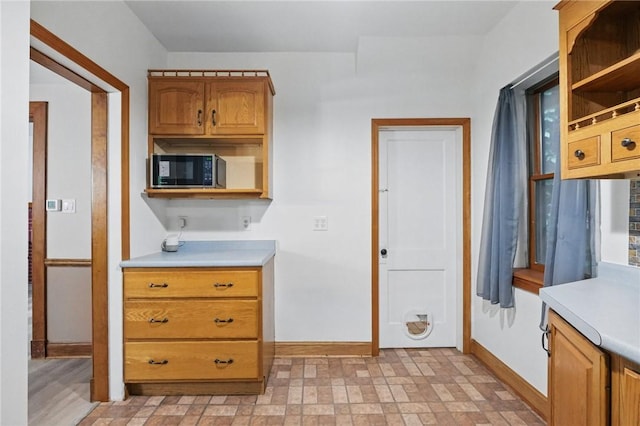 3855 Hiawatha St, Brighton Heights, PA 15212 - kitchen with baseboards, light countertops, open shelves, and brown cabinets