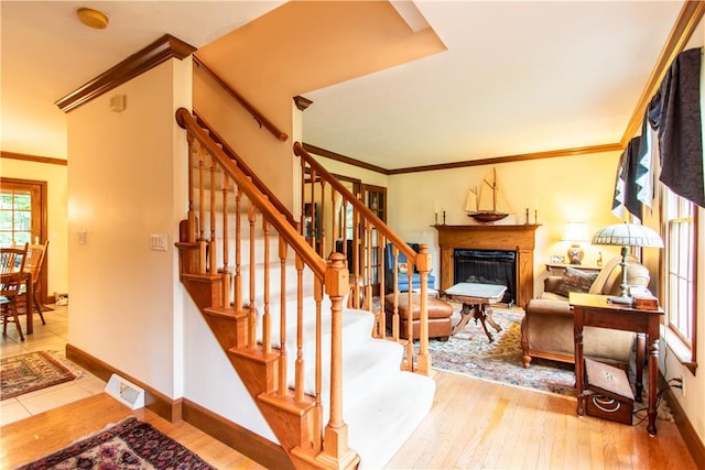 101 Timber Ct, Franklin Twp But, PA 16052 - stairs featuring hardwood / wood-style flooring, a glass covered fireplace, baseboards, and ornamental molding