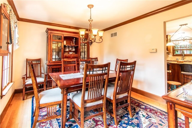 101 Timber Ct, Franklin Twp But, PA 16052 - dining space featuring a chandelier, wood finished floors, crown molding, and baseboards