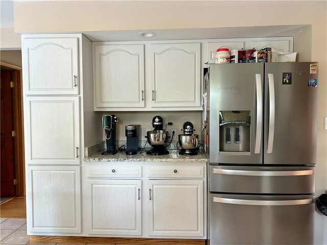 121 Cardinal Dr, East Franklin Twp, PA 16201 - kitchen featuring stainless steel fridge with ice dispenser, white cabinets, light stone counters, and light tile patterned floors