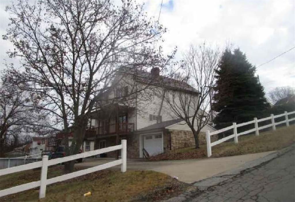 1860 Ohio Ave, West Mifflin, PA 15122 - view of property exterior with stone siding, a garage, and a chimney