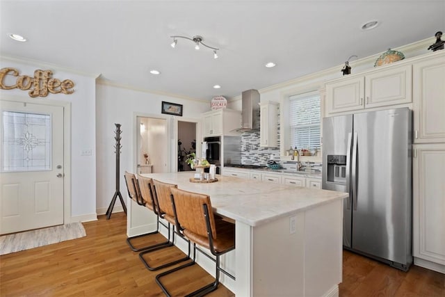 2700 Sumner St, South Side, PA 15203 - kitchen with stainless steel refrigerator with ice dispenser, wall chimney range hood, crown molding, a center island, and backsplash