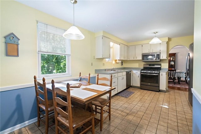 152 N Jamestown Rd, Moon/Crescent Twp, PA 15108 - kitchen with appliances with stainless steel finishes, arched walkways, hanging light fixtures, light tile patterned flooring, and white cabinetry