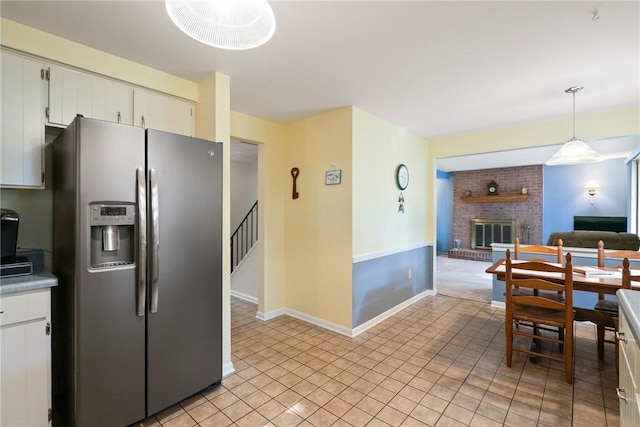 152 N Jamestown Rd, Moon/Crescent Twp, PA 15108 - kitchen featuring stainless steel fridge with ice dispenser, a brick fireplace, light tile patterned floors, light countertops, and open floor plan