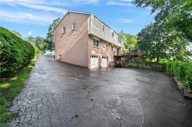152 N Jamestown Rd, Moon/Crescent Twp, PA 15108 - view of side of home with asphalt driveway, a garage, brick siding, and a wooden deck