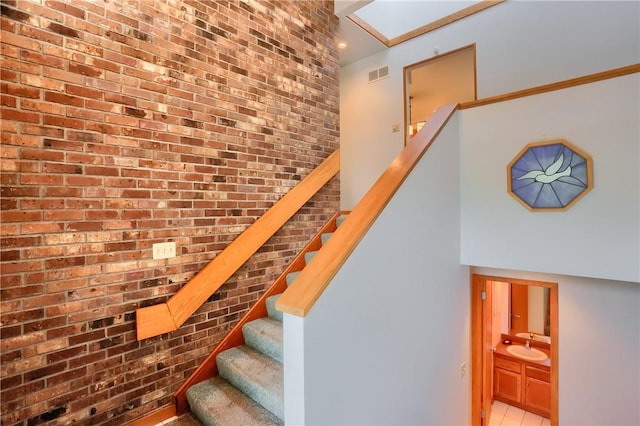 199 Rustic Dr, North Huntingdon, PA 15642 - staircase with brick wall and tile patterned flooring