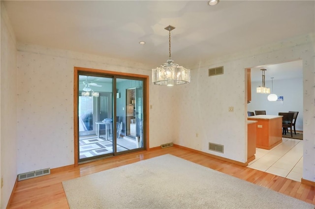 199 Rustic Dr, North Huntingdon, PA 15642 - spare room featuring a chandelier, light wood-type flooring, baseboards, and wallpapered walls