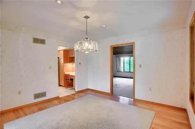 199 Rustic Dr, North Huntingdon, PA 15642 - unfurnished room with light wood-style floors, a chandelier, and baseboards