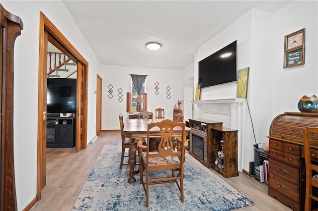 104 Overholt Dr, Scottdale, PA 15683 - dining room with a glass covered fireplace, light wood finished floors, and baseboards