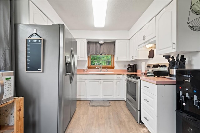 104 Overholt Dr, Scottdale, PA 15683 - kitchen featuring appliances with stainless steel finishes, under cabinet range hood, a sink, light wood-style flooring, and white cabinets