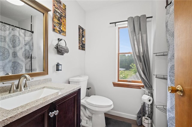 104 Overholt Dr, Scottdale, PA 15683 - bathroom featuring toilet, vanity, baseboards, and wood finished floors