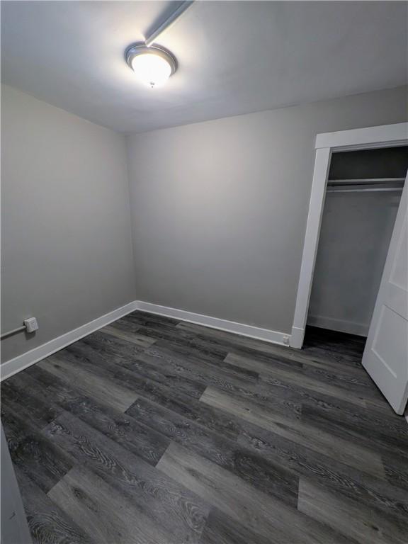 1217 Scott St, Mckeesport, PA 15132 - unfurnished bedroom with dark wood-style floors, baseboards, and a closet
