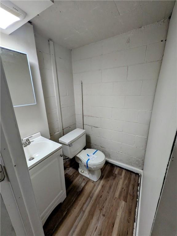 1105 Parkside Dr, Rear Brackenridge, PA 15014 - bathroom with toilet, vanity, wood finished floors, and concrete block wall