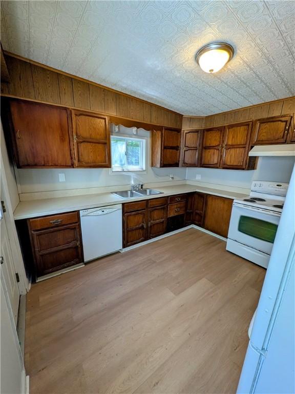 518 Glenn St, Wilmerding, PA 15148 - kitchen featuring white appliances, an ornate ceiling, under cabinet range hood, brown cabinetry, and a sink
