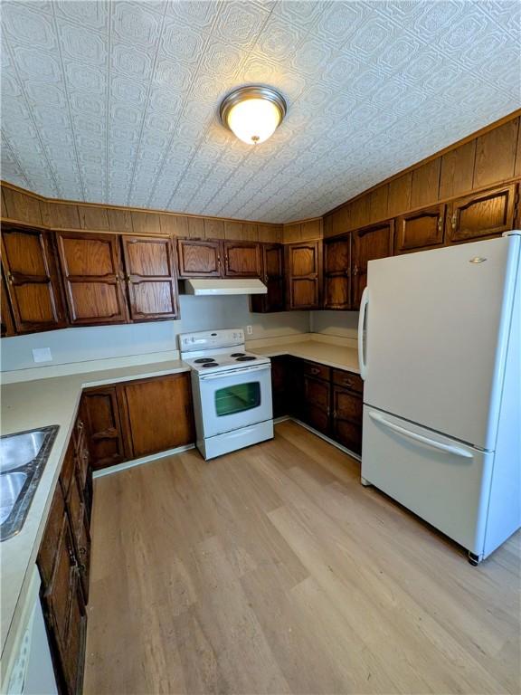 518 Glenn St, Wilmerding, PA 15148 - kitchen featuring white appliances, under cabinet range hood, an ornate ceiling, and light wood-style floors