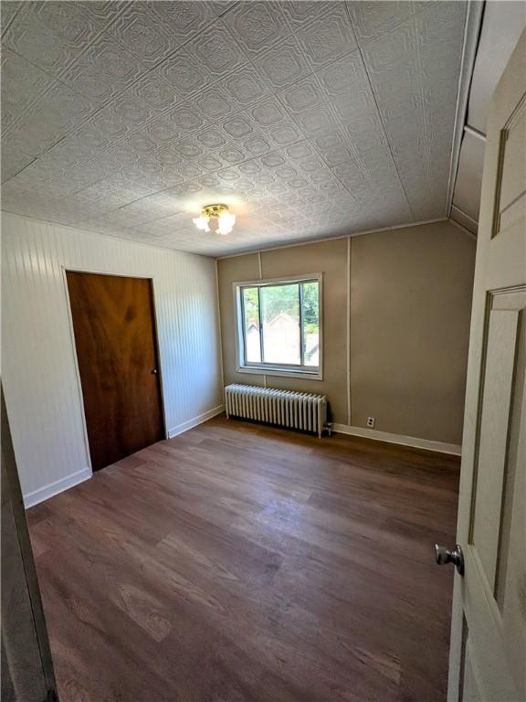 518 Glenn St, Wilmerding, PA 15148 - unfurnished bedroom featuring radiator heating unit, wood finished floors, baseboards, and an ornate ceiling
