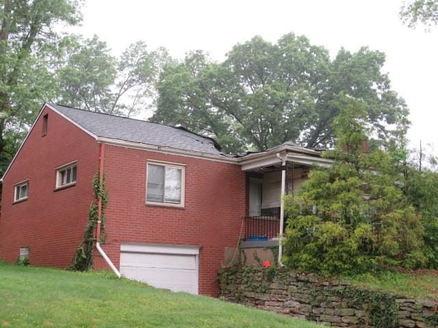 1845 Atkinson Pl, Wilkinsburg, PA 15235 - view of home's exterior featuring a garage, brick siding, and a yard