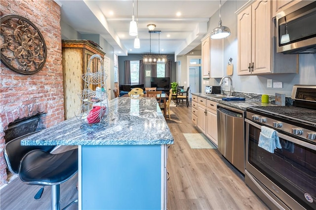 1701 Meadville St, Fineview, PA 15214 - kitchen with appliances with stainless steel finishes, a sink, a breakfast bar area, light wood-style flooring, and light stone countertops