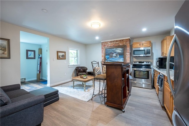 1701 Meadville St, Fineview, PA 15214 - kitchen featuring appliances with stainless steel finishes, open floor plan, light wood finished floors, light countertops, and a kitchen breakfast bar