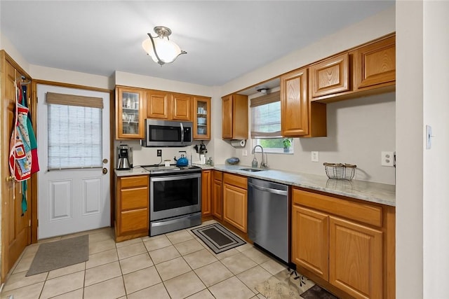 2920 Roland Ave, Baldwin Boro, PA 15227 - kitchen featuring appliances with stainless steel finishes, a sink, brown cabinets, light tile patterned flooring, and glass insert cabinets