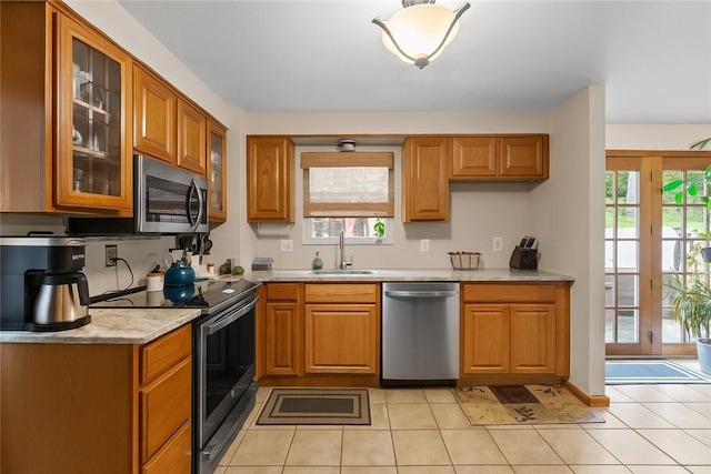 2920 Roland Ave, Baldwin Boro, PA 15227 - kitchen with stainless steel appliances, a sink, light countertops, glass insert cabinets, and brown cabinetry