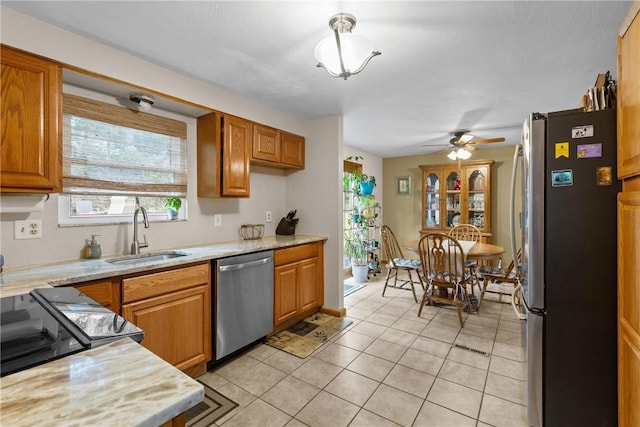 2920 Roland Ave, Baldwin Boro, PA 15227 - kitchen with appliances with stainless steel finishes, a sink, light tile patterned floors, and brown cabinets