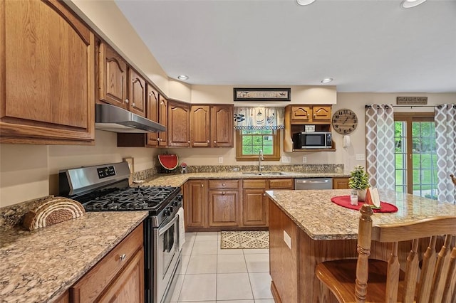 1408 Fernledge Dr, Shaler, PA 15101 - kitchen with stainless steel appliances, under cabinet range hood, a sink, light tile patterned floors, and brown cabinets