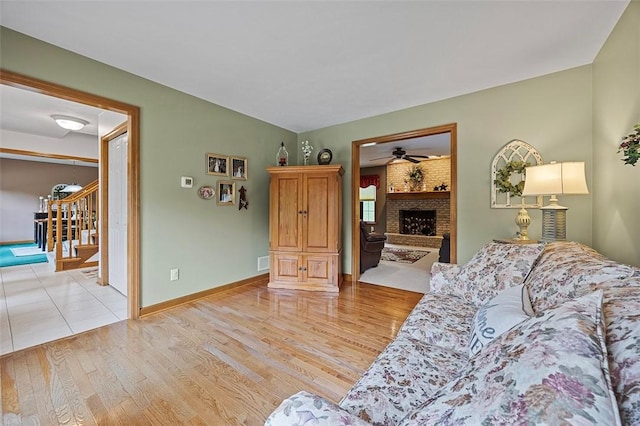 1408 Fernledge Dr, Shaler, PA 15101 - living area featuring light wood finished floors, ceiling fan, a fireplace, stairway, and baseboards