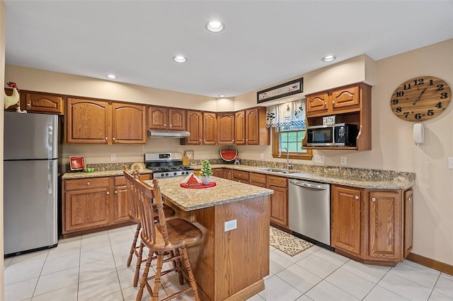 1408 Fernledge Dr, Shaler, PA 15101 - kitchen featuring appliances with stainless steel finishes, a sink, under cabinet range hood, brown cabinets, and a kitchen island
