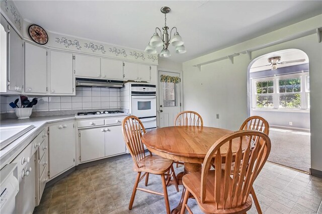 1060 S Hermitage Rd, Hermitage, PA 16148 - kitchen with white appliances, light countertops, under cabinet range hood, a chandelier, and tasteful backsplash