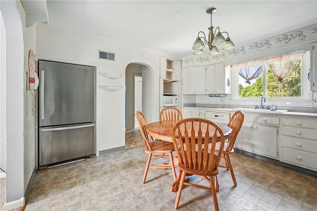 1060 S Hermitage Rd, Hermitage, PA 16148 - dining area featuring arched walkways, a chandelier, and baseboards