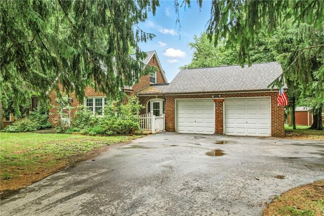 1060 S Hermitage Rd, Hermitage, PA 16148 - view of front of house with an attached garage, asphalt driveway, brick siding, and a shingled roof