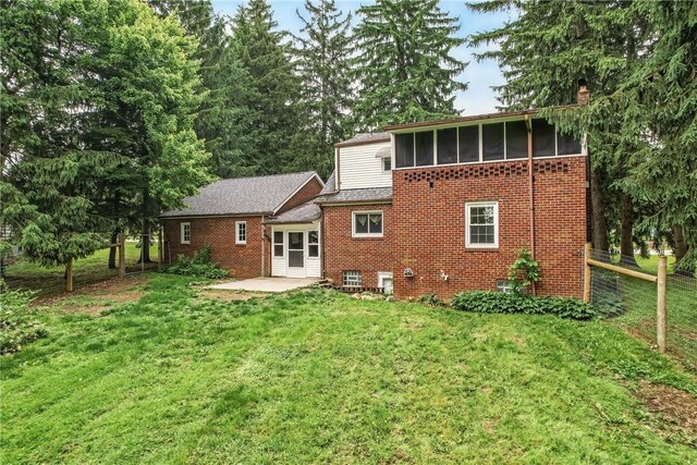 1060 S Hermitage Rd, Hermitage, PA 16148 - rear view of house featuring a patio, brick siding, a sunroom, and a chimney