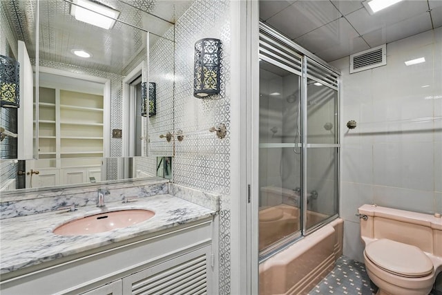 5048 5th Ave Unit 101, Shadyside, PA 15232 - full bathroom with shower / bath combination with glass door, vanity, toilet, and tile walls