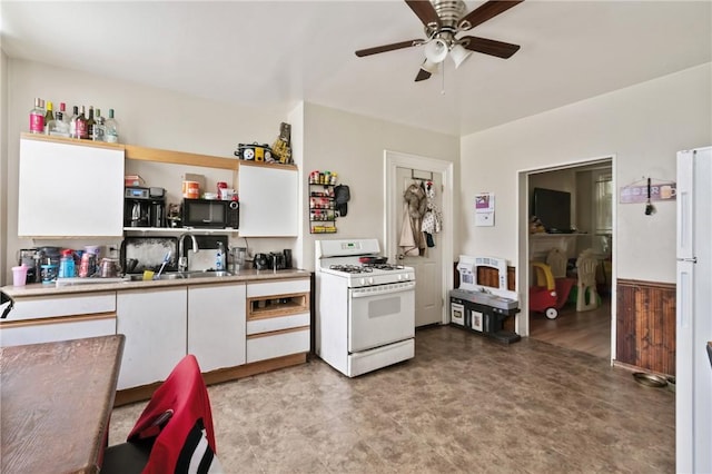1332 Diana St, Troy Hill, PA 15212 - kitchen featuring white gas range oven, a sink, white cabinetry, ceiling fan, and black microwave