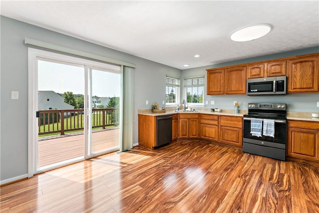 2000 Michael Dr, Baldwin Boro, PA 15227 - kitchen with appliances with stainless steel finishes, a sink, brown cabinetry, light countertops, and wood finished floors